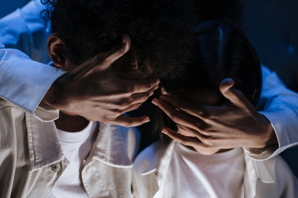 Two children showing affectionate protection by covering each other's eyes, symbolizing care and togetherness.